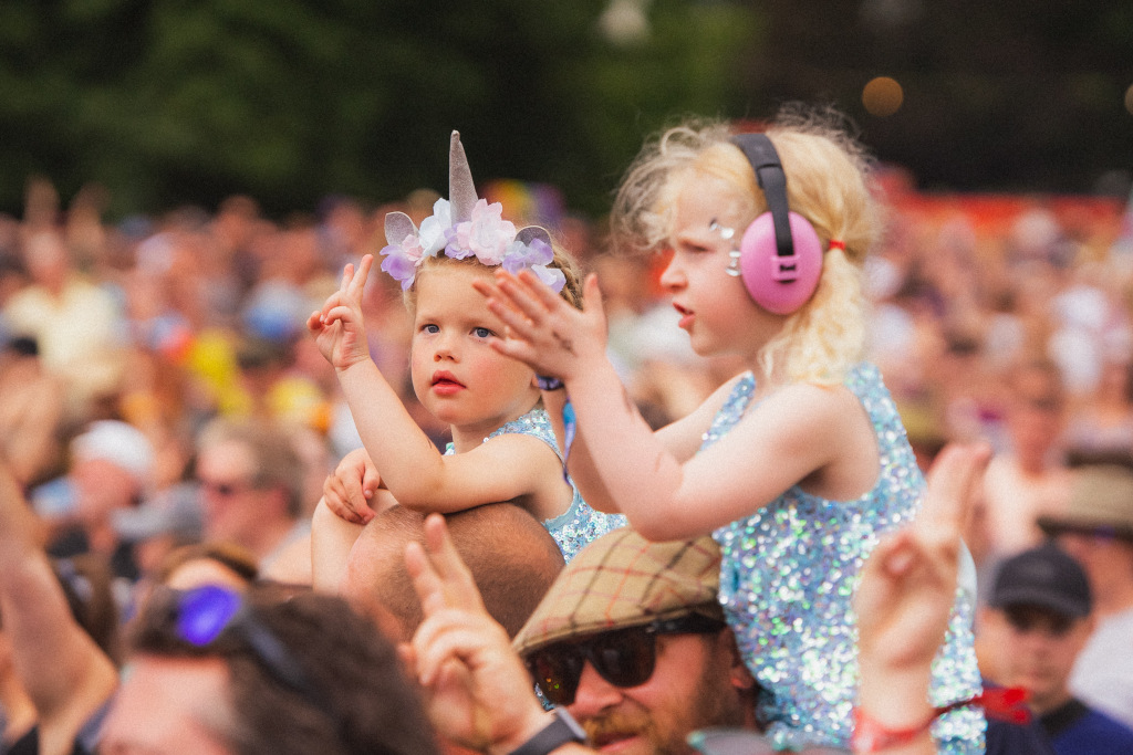 two blonde girls on shoulders in festival crowd