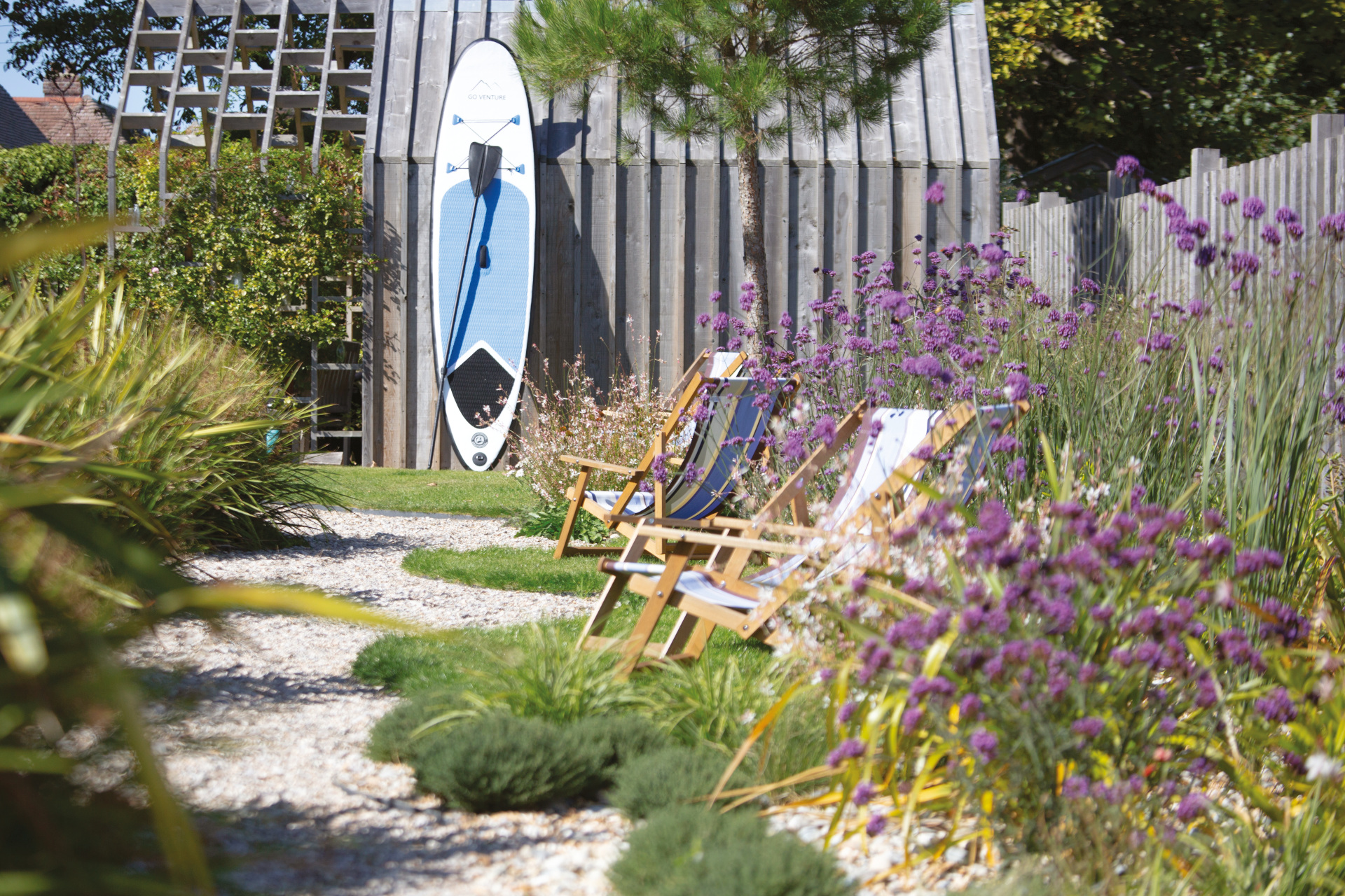 Outdoor space with deck chairs and surfboard