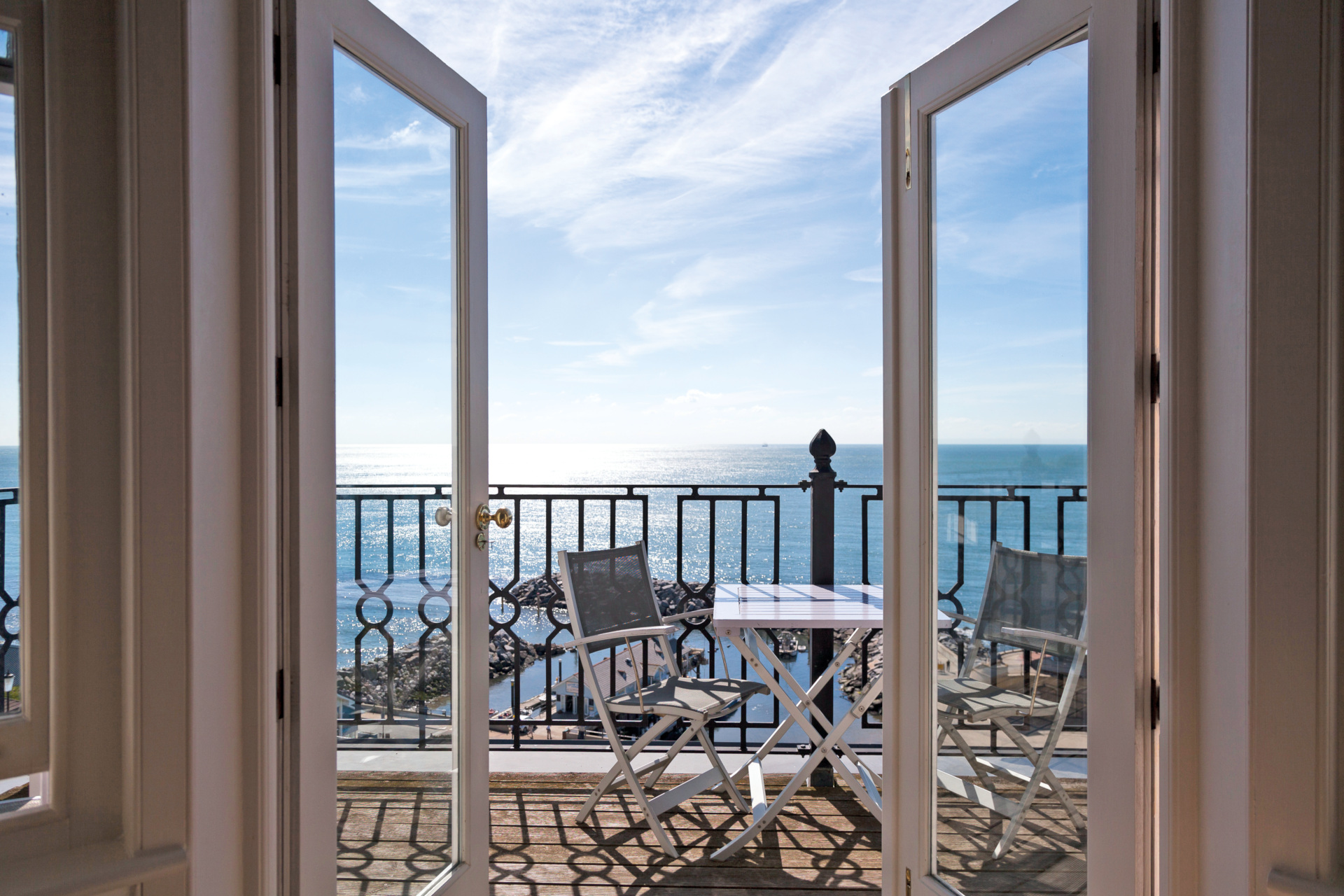Open doors leading onto balcony overlooking the sea