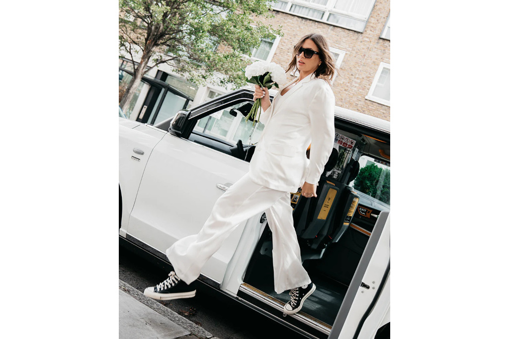 Woman in white suit getting out of white car