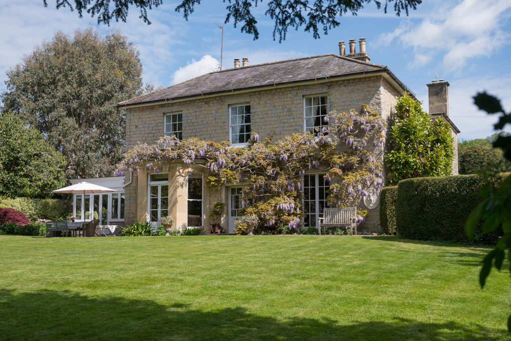purple wisteria clad georgian property country home exterior shot from garden