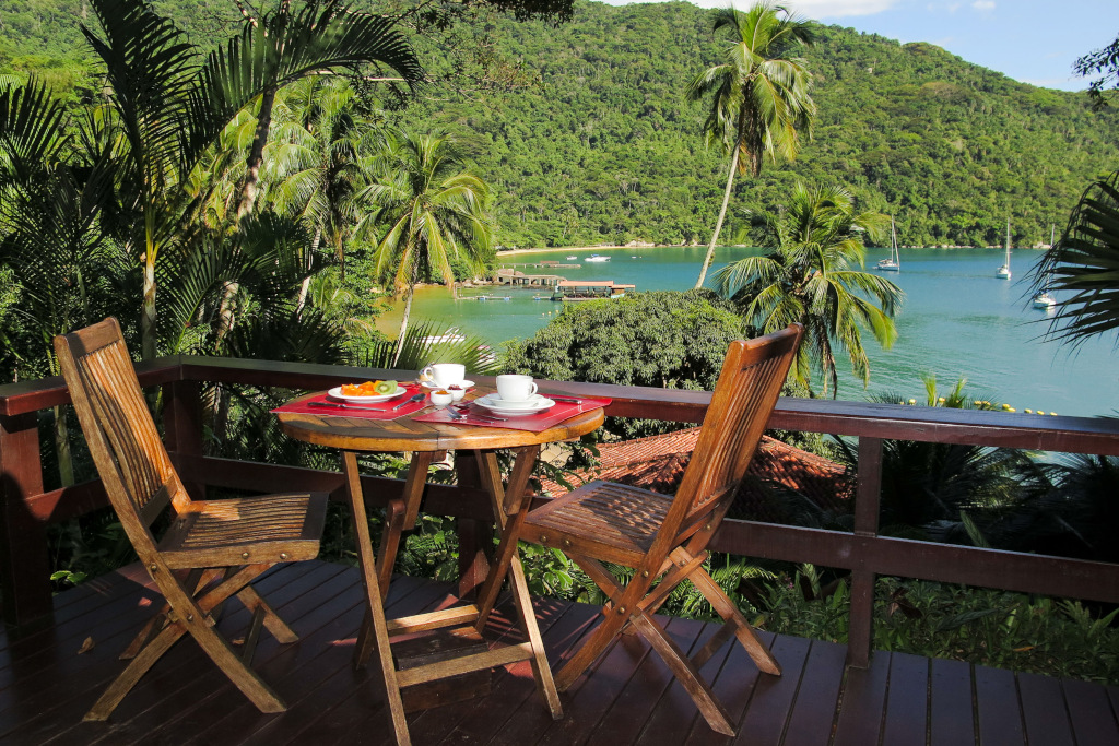 atlantica jungle lodge view of jungle and sea, with two chairs and tables and tea laid out
