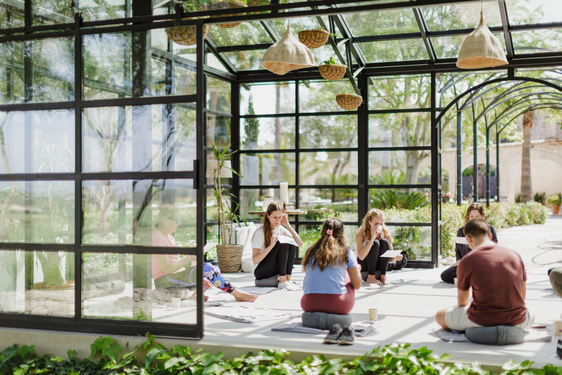 people sitting on floor in a conservatory wellness class