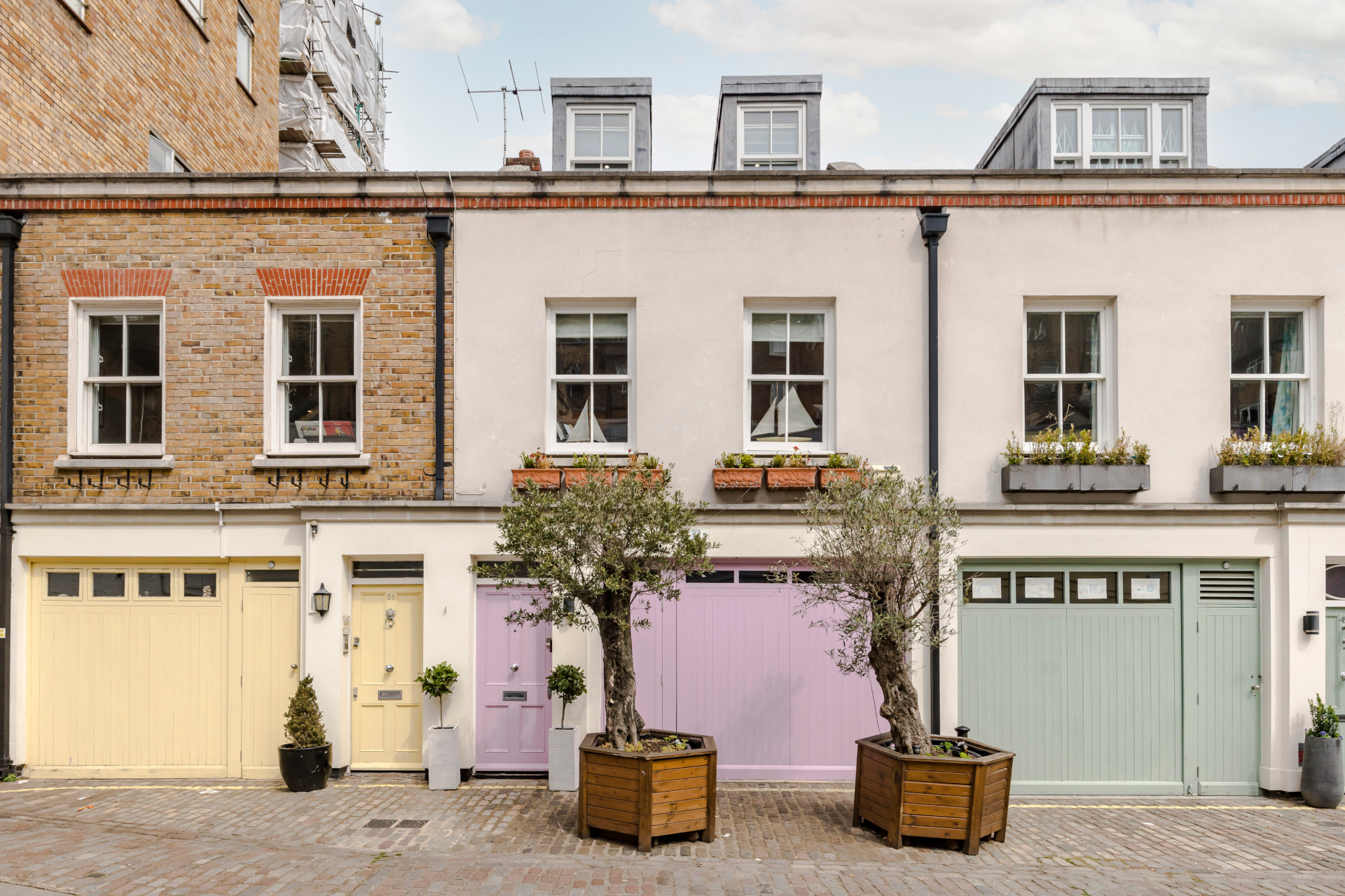 pretty mews houses with yellow, lilac, and mint garages