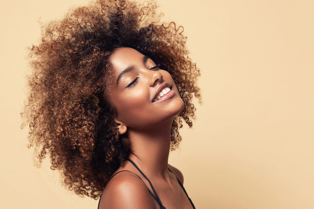 a woman smiling with a yellow background