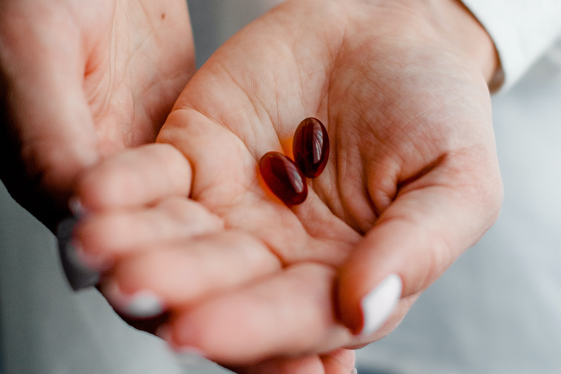 a women's hands hold a beauty pill