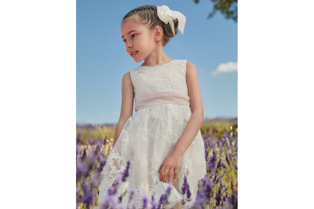 Girl in lavender field wearing white dress with pink sash