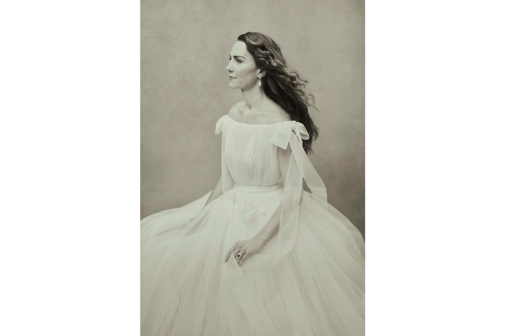 Portrait photo of the Duchess of Cambridge, she sits in a tulle Alexander McQueen gown looking off to the side. The photo is in greyscale
