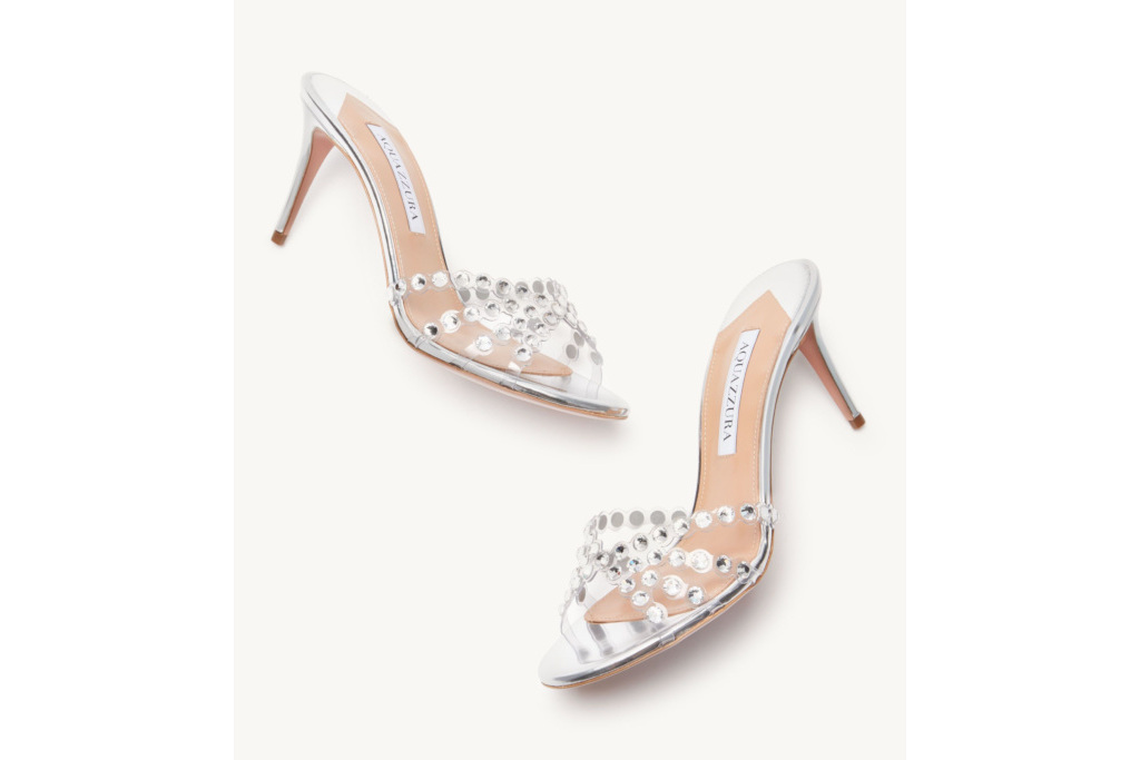 A pair of see-through mules with silver gemstones on the straps