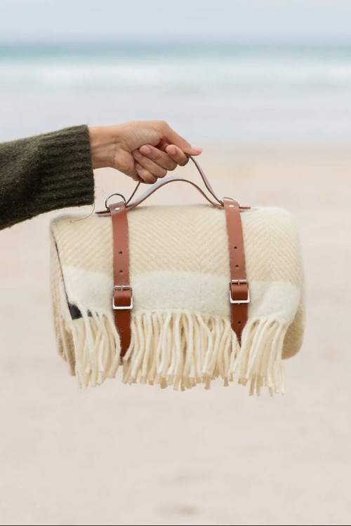 Hand holding beige rug from Atlantic Blankets