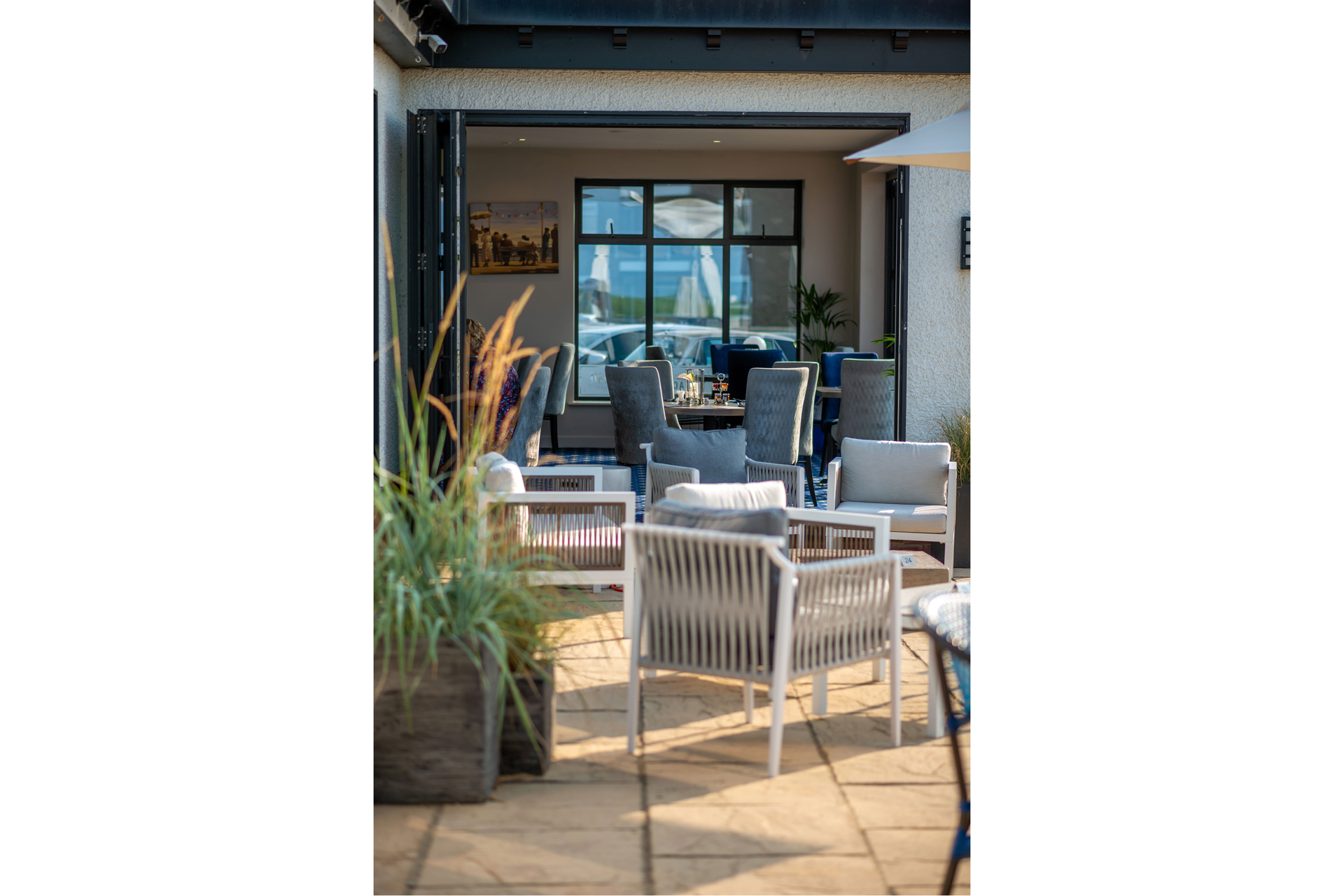 Chairs in the sun on the terrace at The Relais Cooden Beach