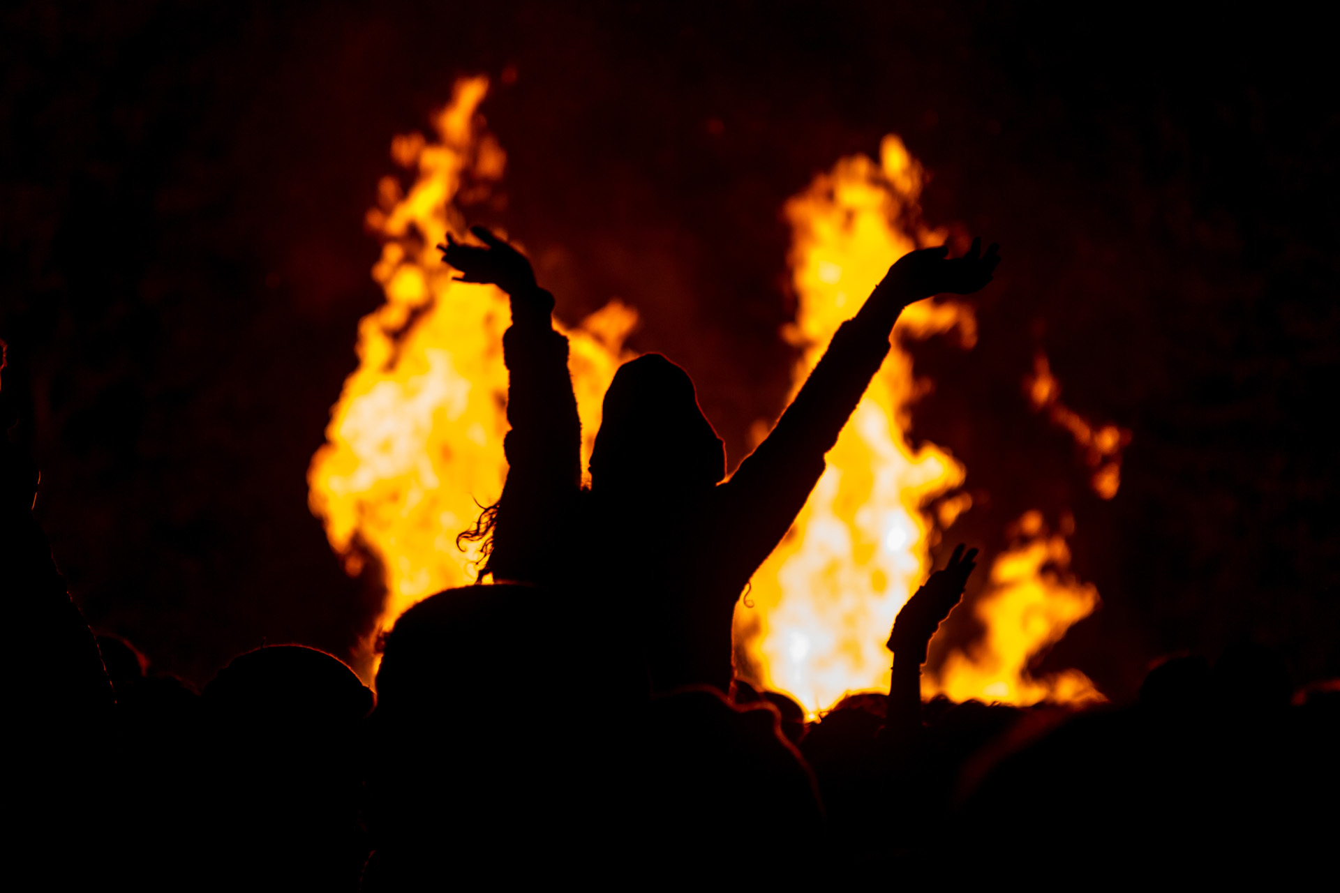 An unrecognisable silhouetted woman in front of a bonfire