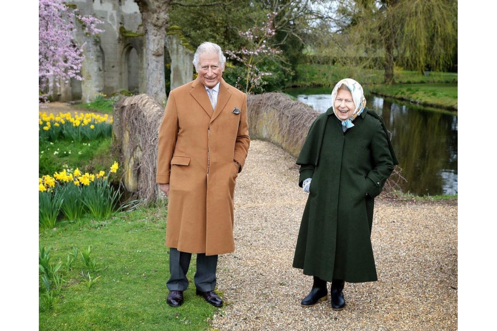 The Queen and the Prince of Wales stood outdoors in coats and boots