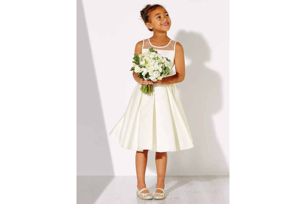 Girl in white bridesmaid dress holding flowers
