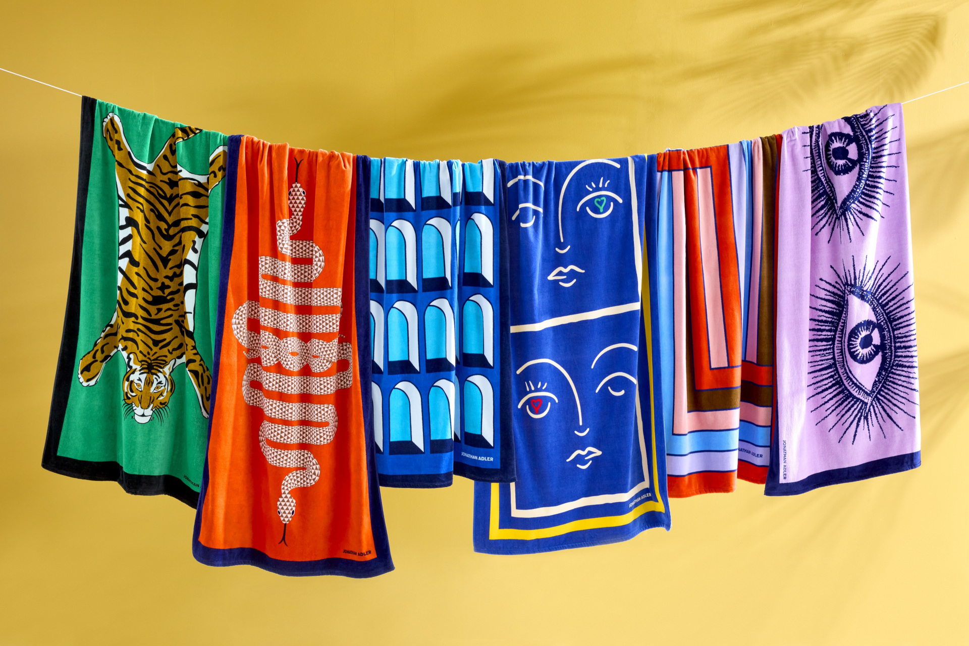 Colourful beach towels hung in a row on a line