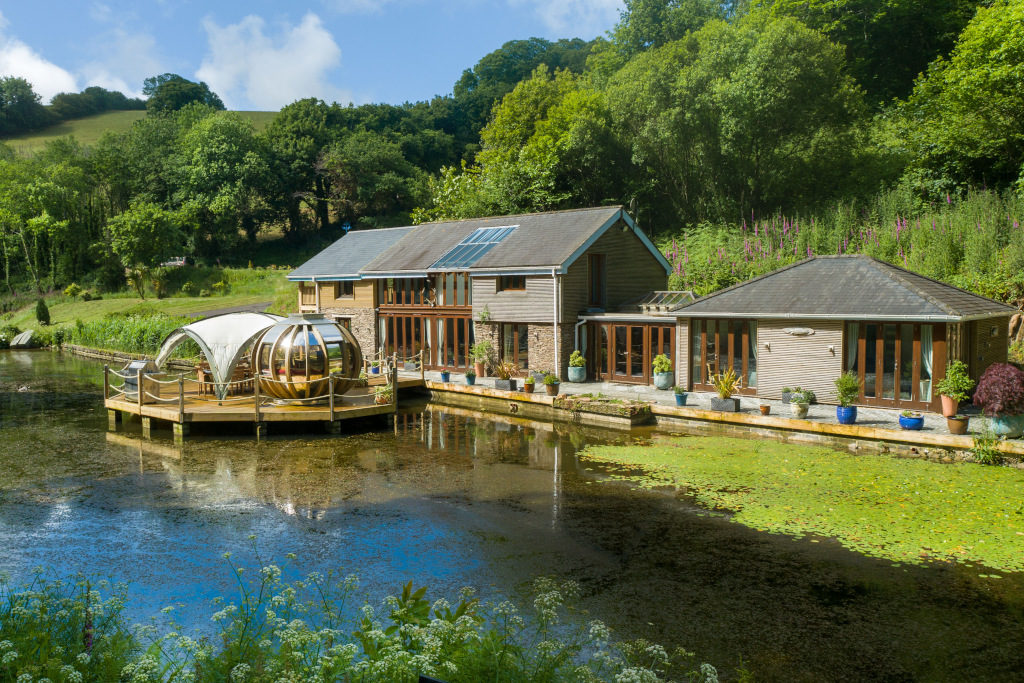 exterior shot of country barn-style lodge on the lake with decking jetty