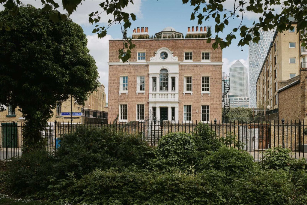 Large Georgian home nestled behind a black fence in the middle of London