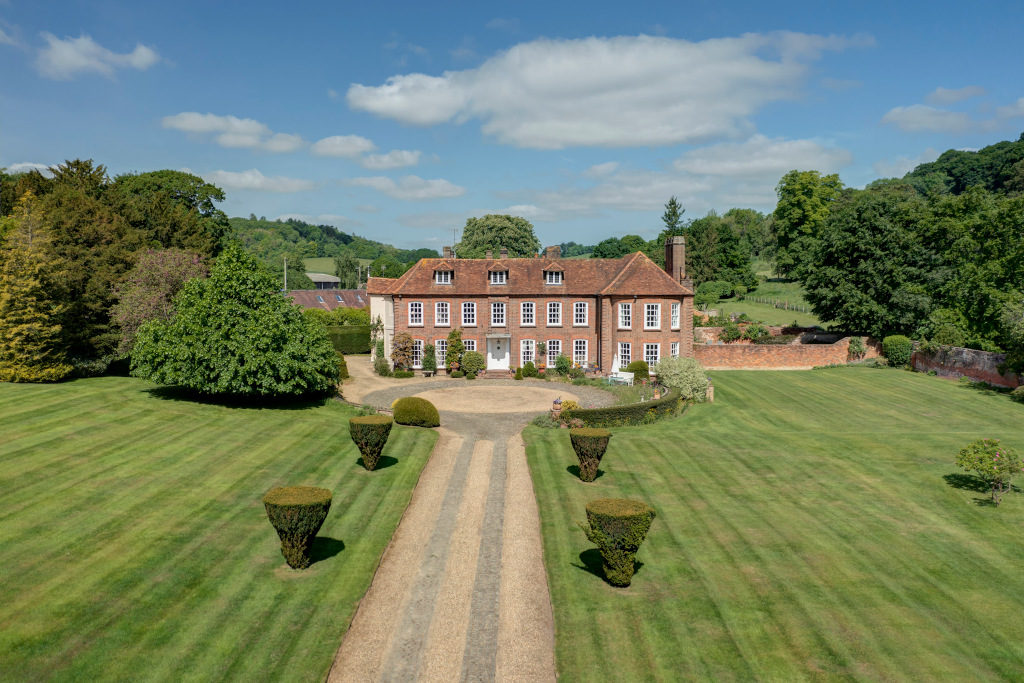 exterior of red brick and white pane window georgian mansion amongst grounds in buckinghamshire