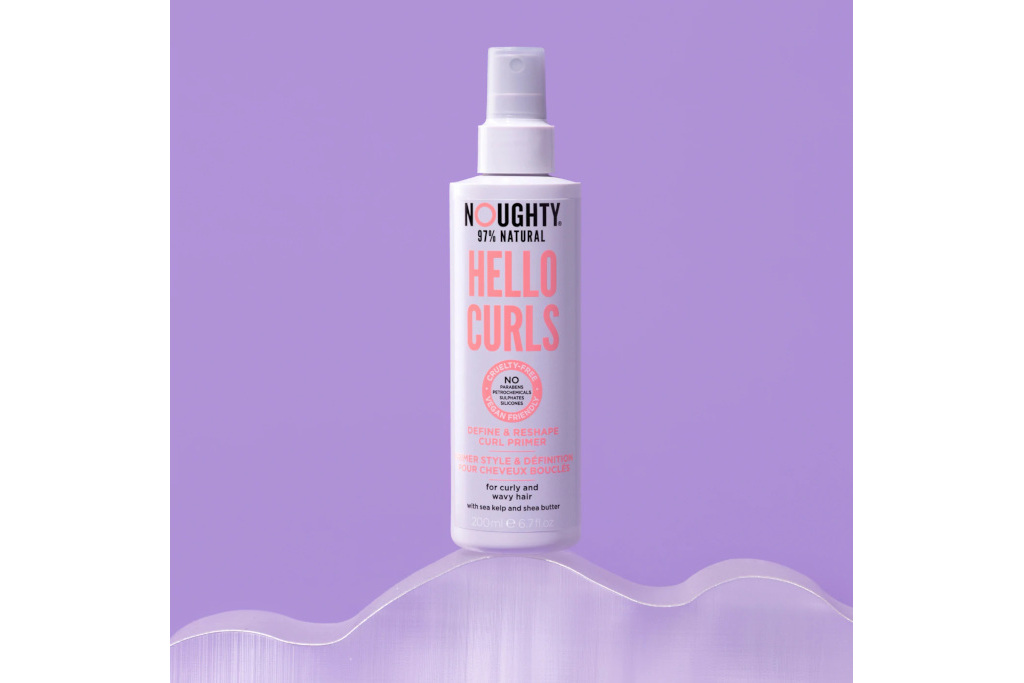 Bottle of curl treatment on purple background