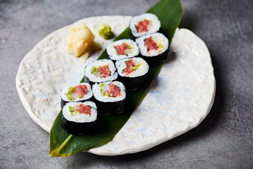 sushi on decorative leaf on white plate at sushisamba