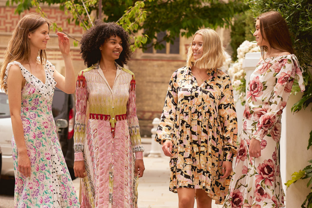 Four models stood together in colourful patterned dresses