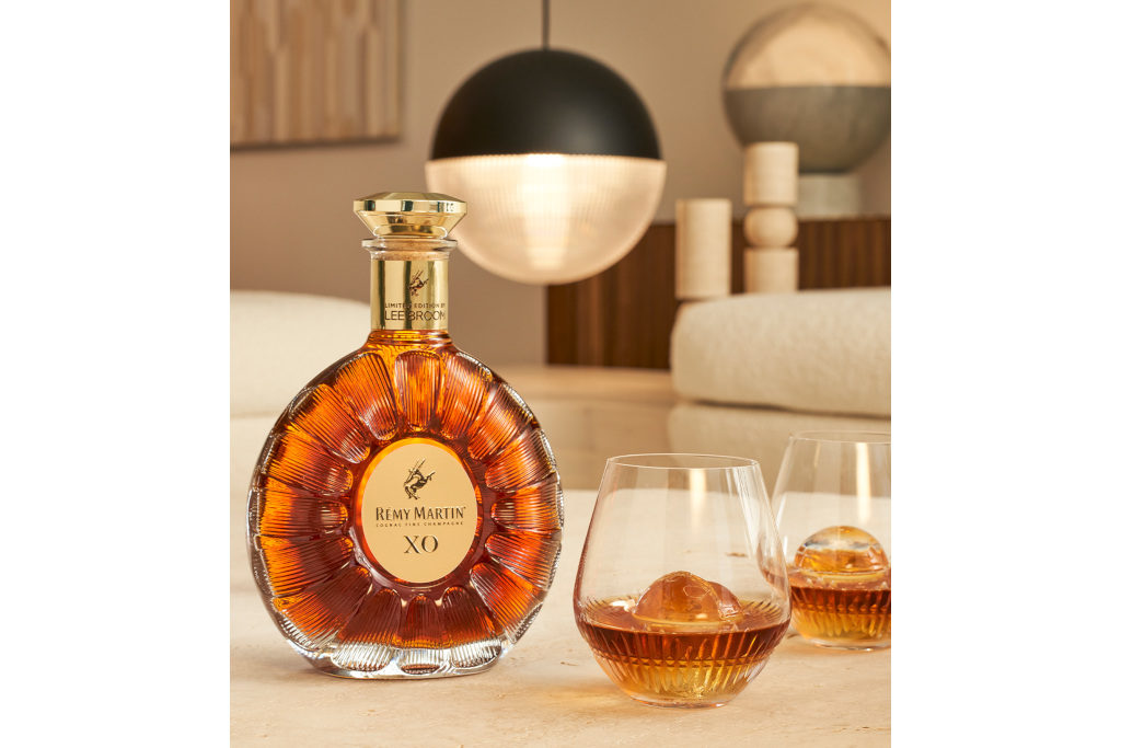 Oval bottle of cognac next to glasses