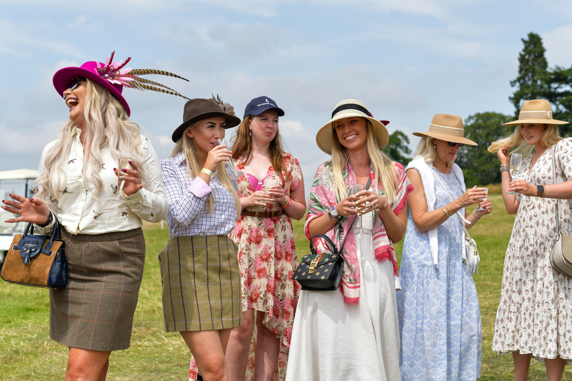 group of five women dressed in country clothes and pretty dresses at the game fair