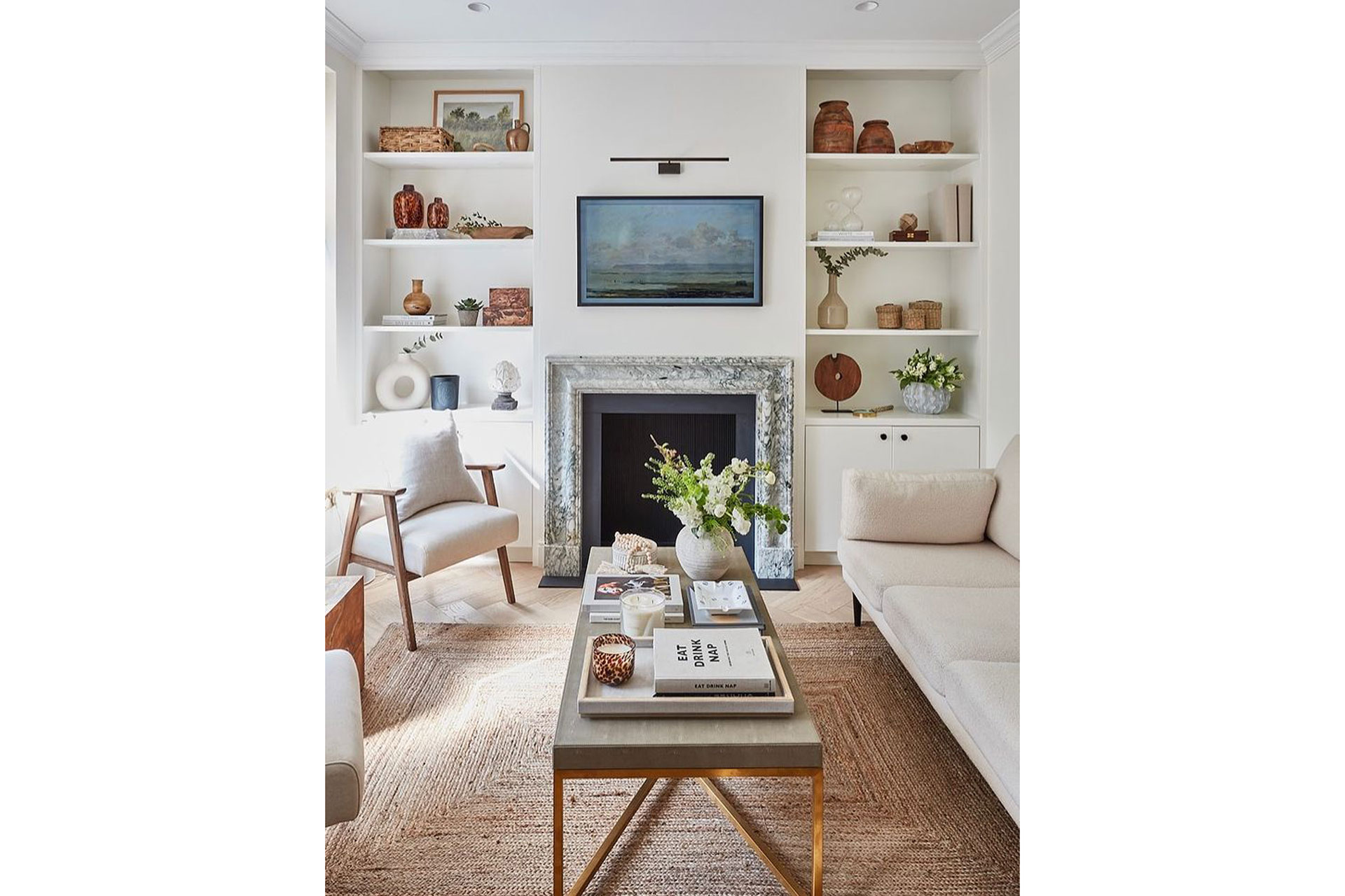 a living room with rattan rug and cream sofas by Cox and Cox