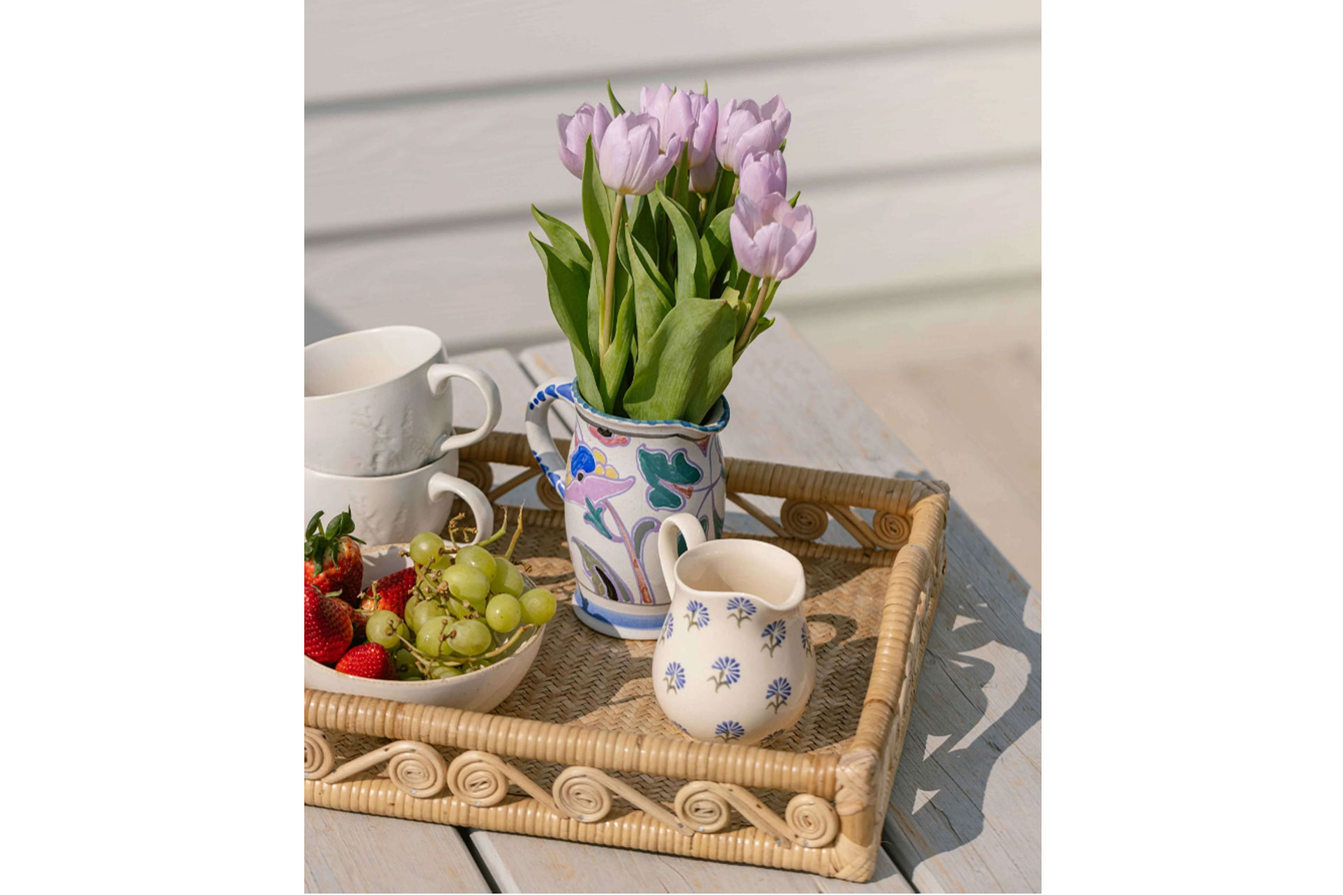 Glasette tray made from straw showing a vase of purple tulips