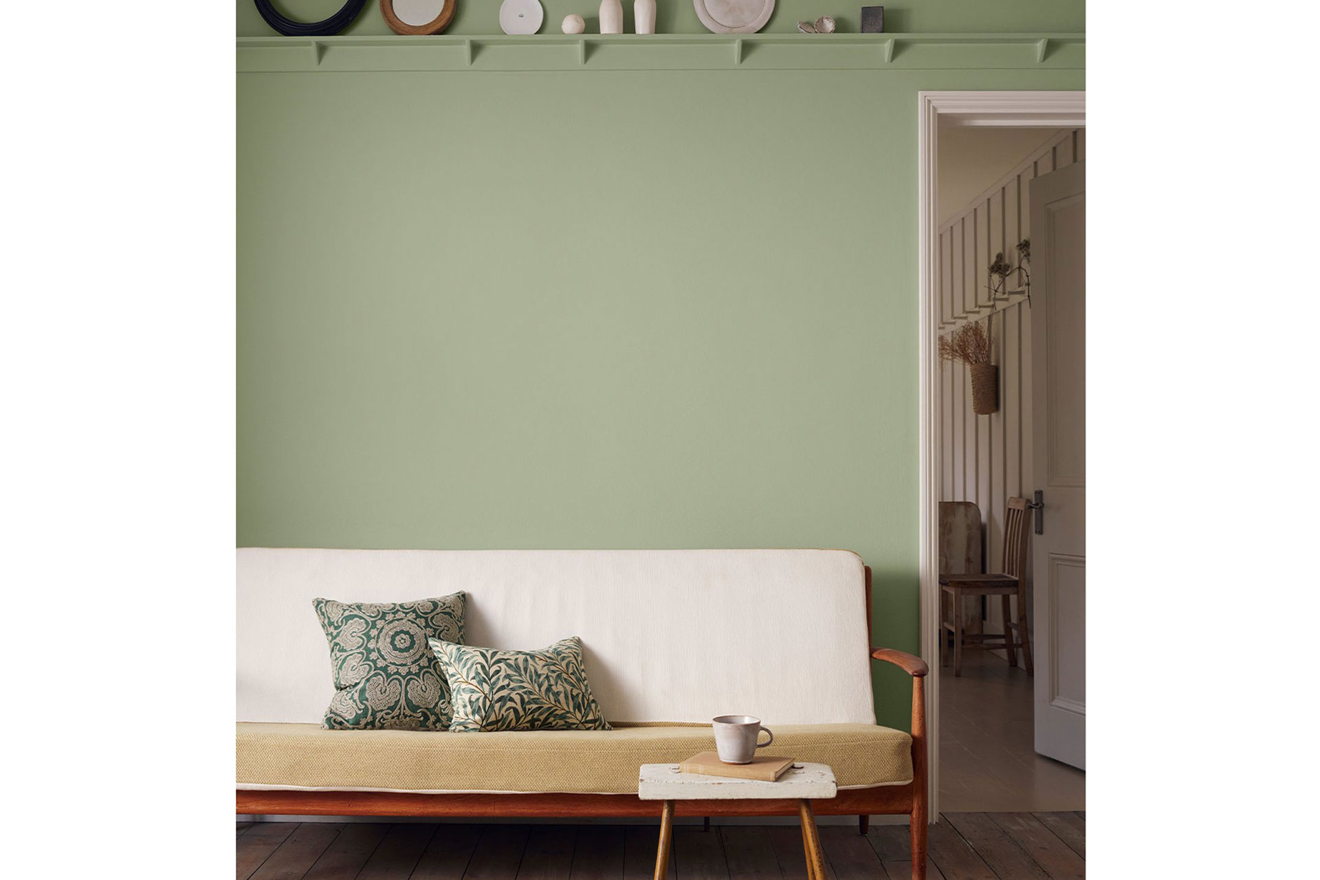 a living room with green paint by Morris & Co