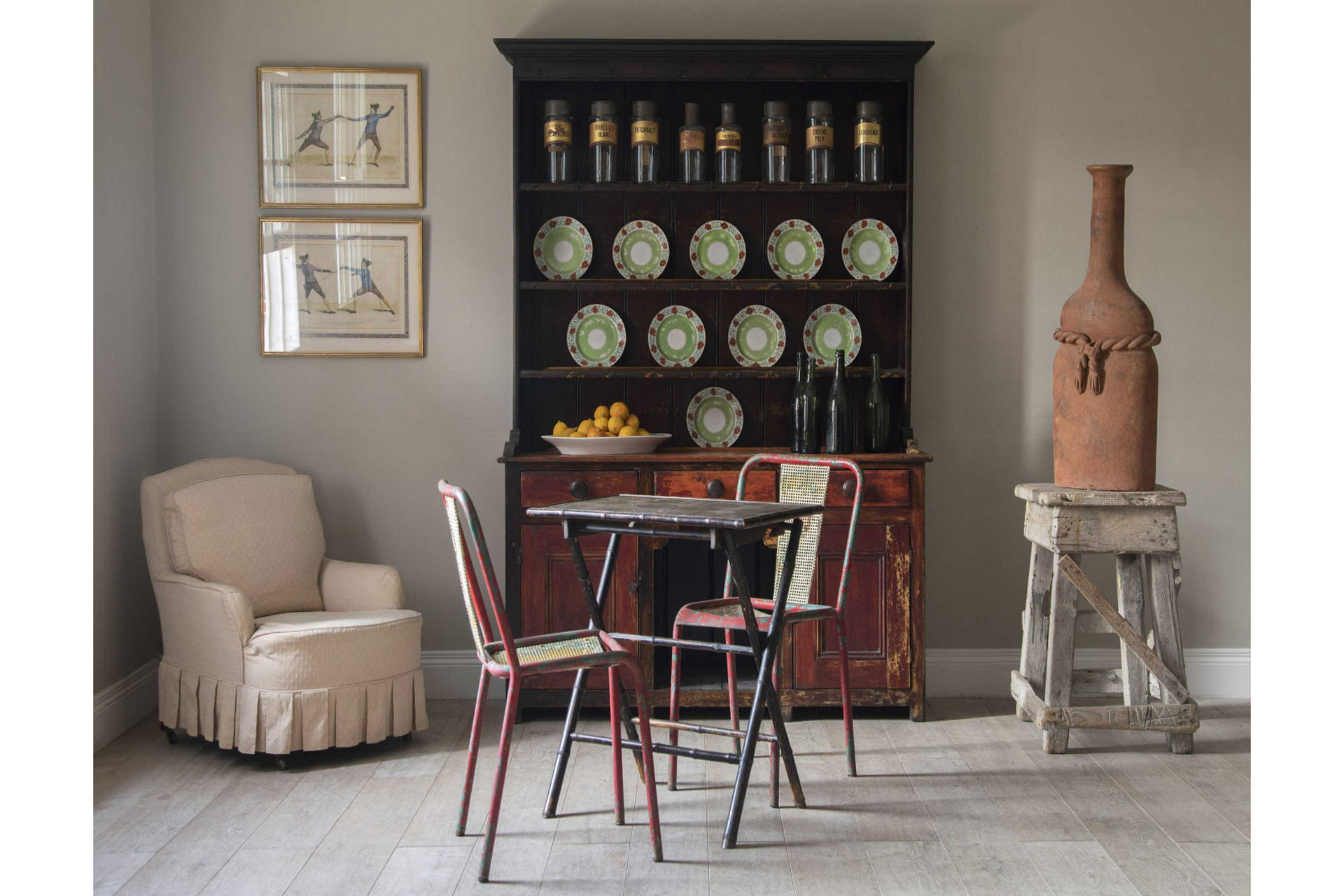 a living room full of antiques, including a dresser, armchair, and a table and two chairs in a historic house. The antiques are sold by Lorford Antiques