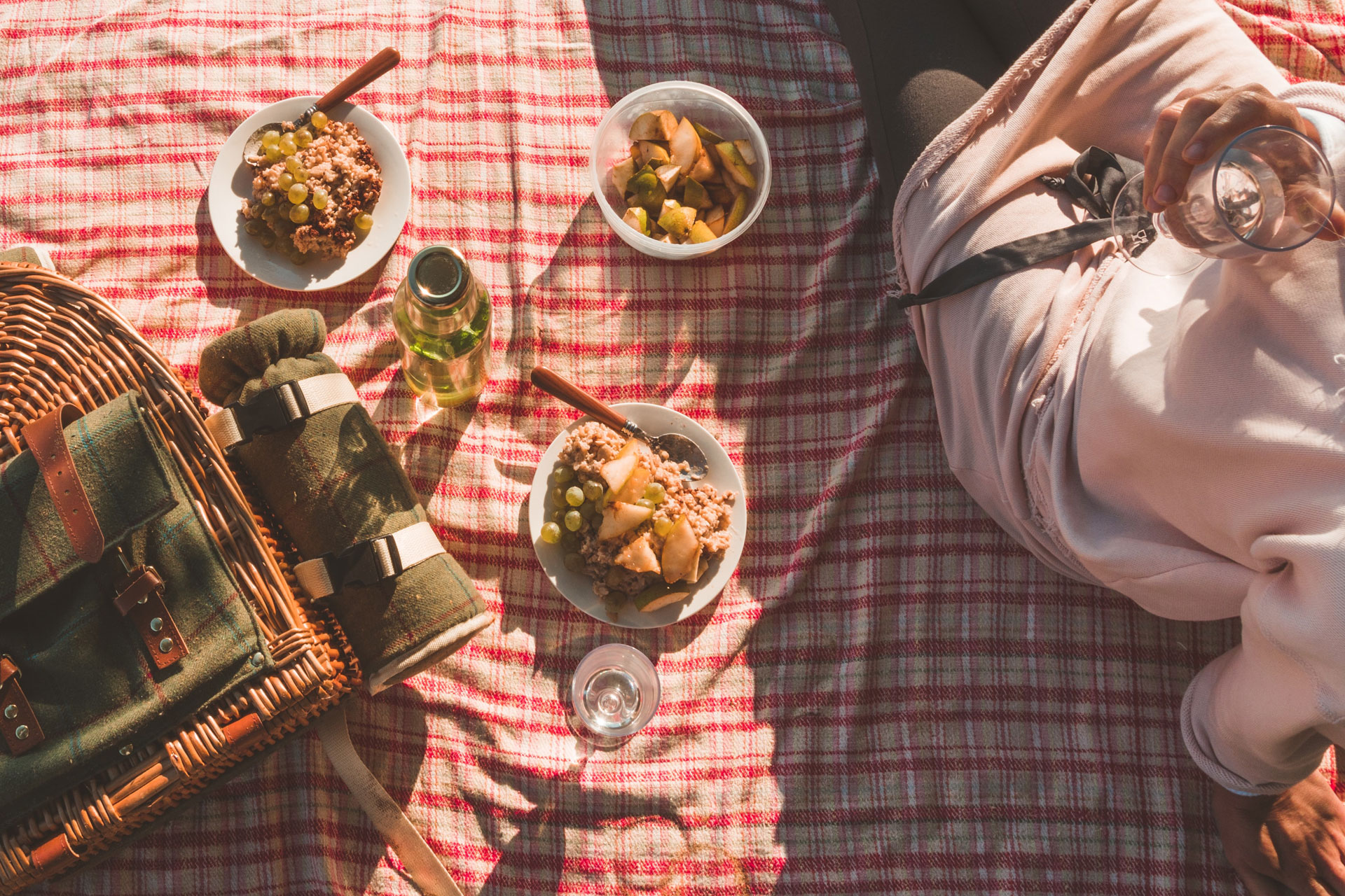 a overhead shot of a luxury picnic basket and food on a picnic blanket