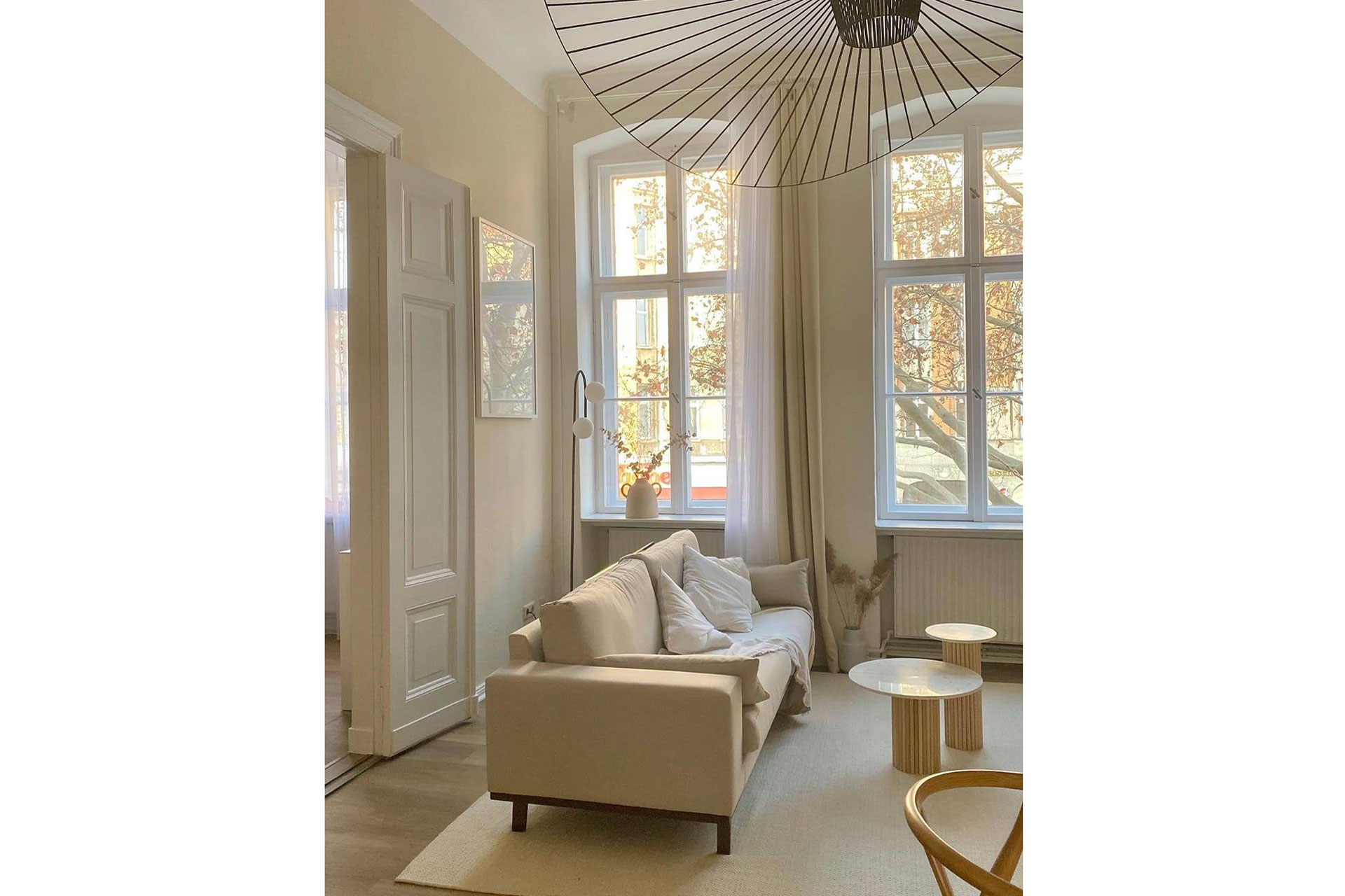 an interior of a town house with a cream sofa and carpet and tables by Mango Home