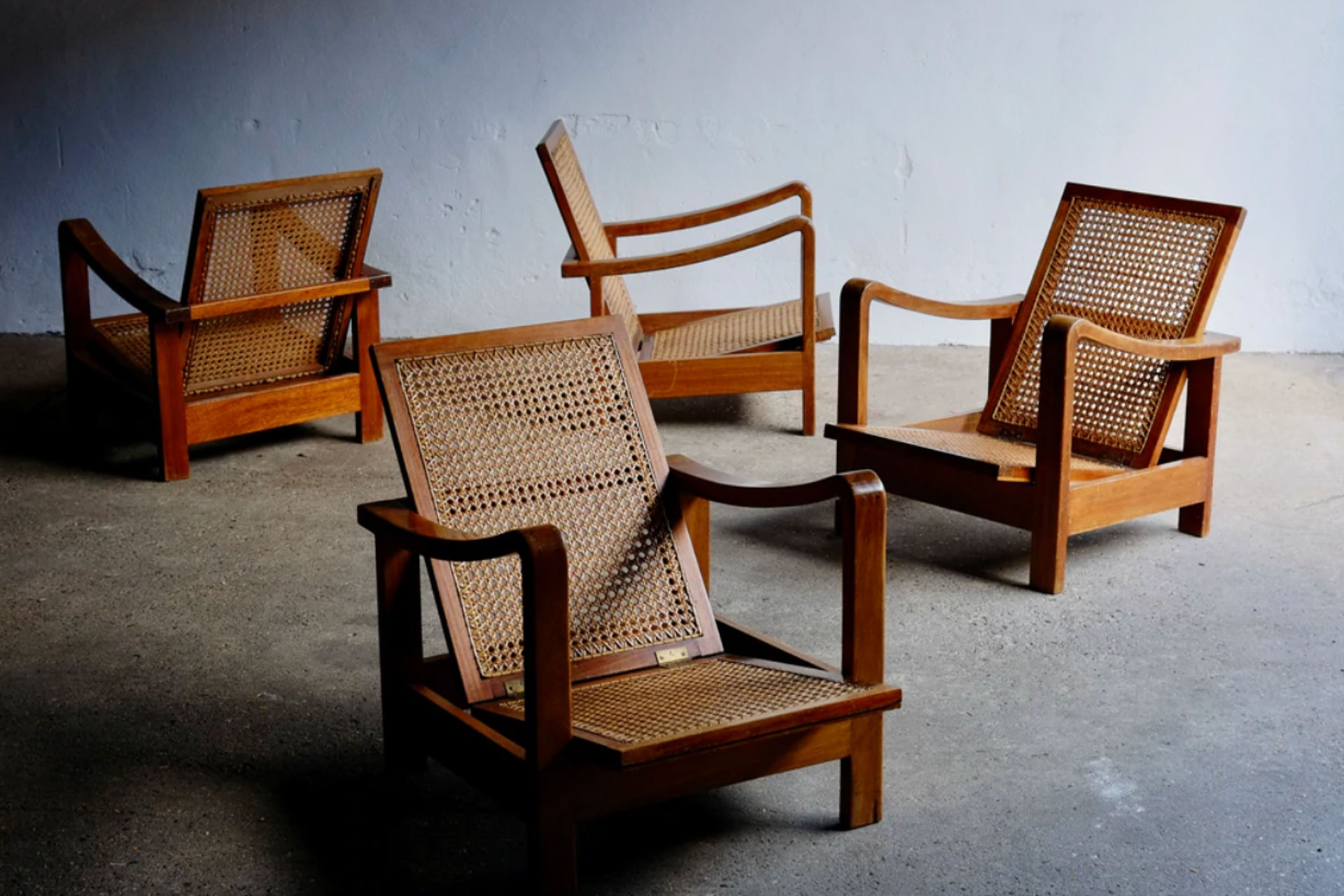 Four Art Deco reclining chairs in a brutalist space, sold by Punch the Clock, which is an antiques store