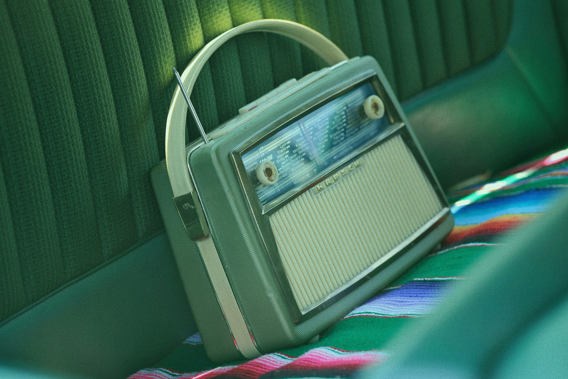a vintage radio in pastel green in a car