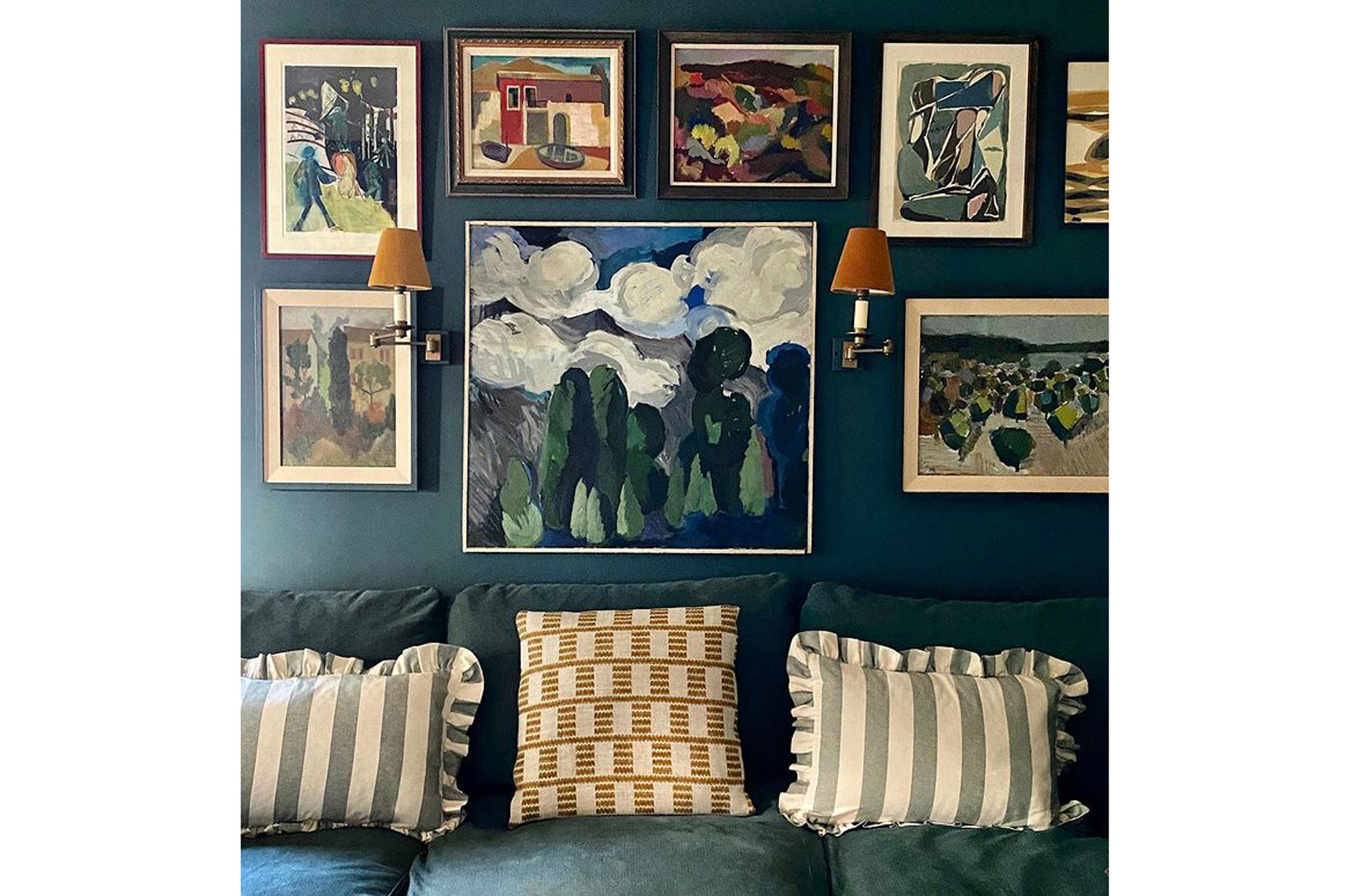blue sofas with framed paintings and ruffled cushions