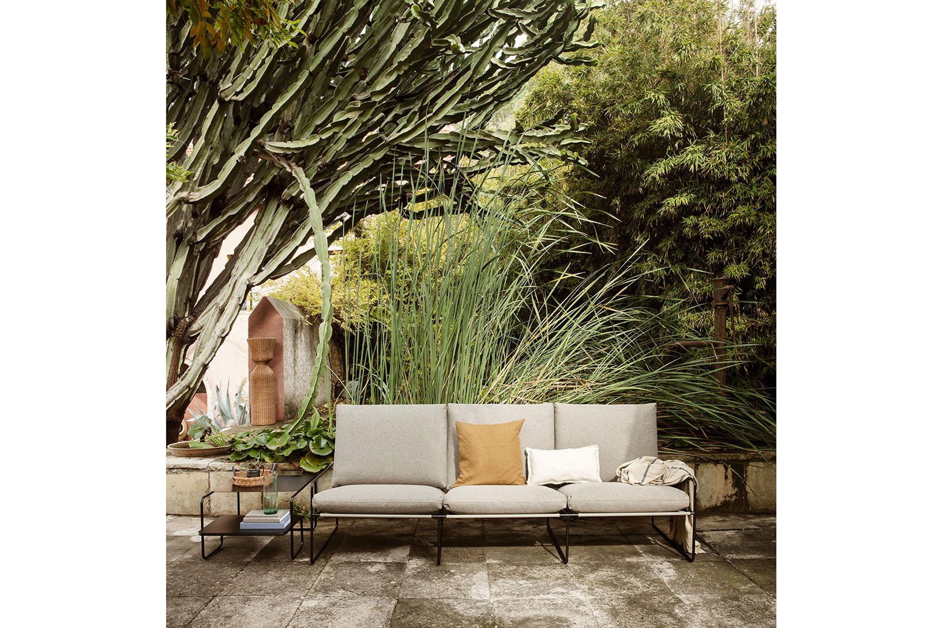 a minimalistic sofa stands outside next to a cactus, the sofa is sold by Twenty Twenty One