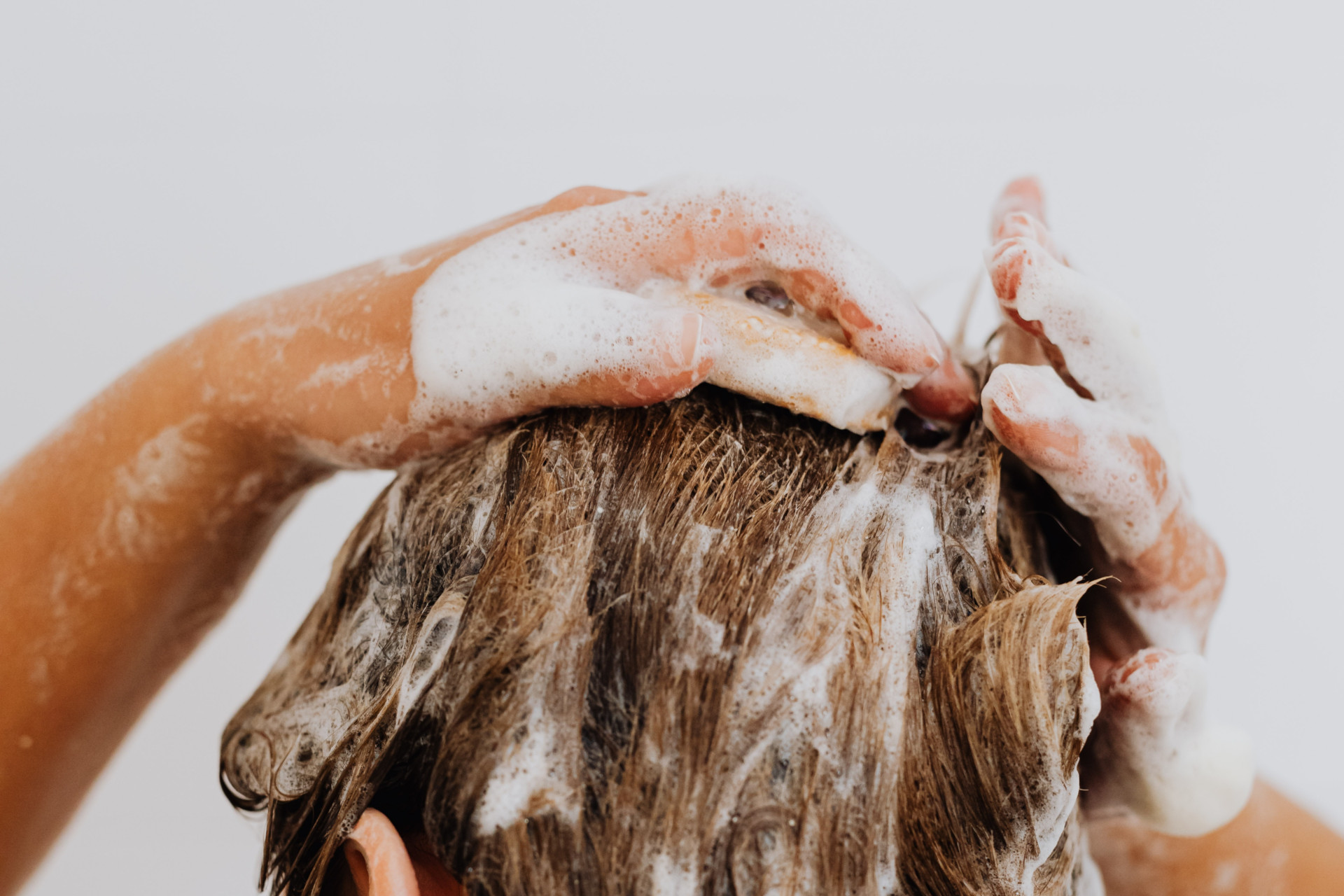 Close up fo woman applying hair products to hair