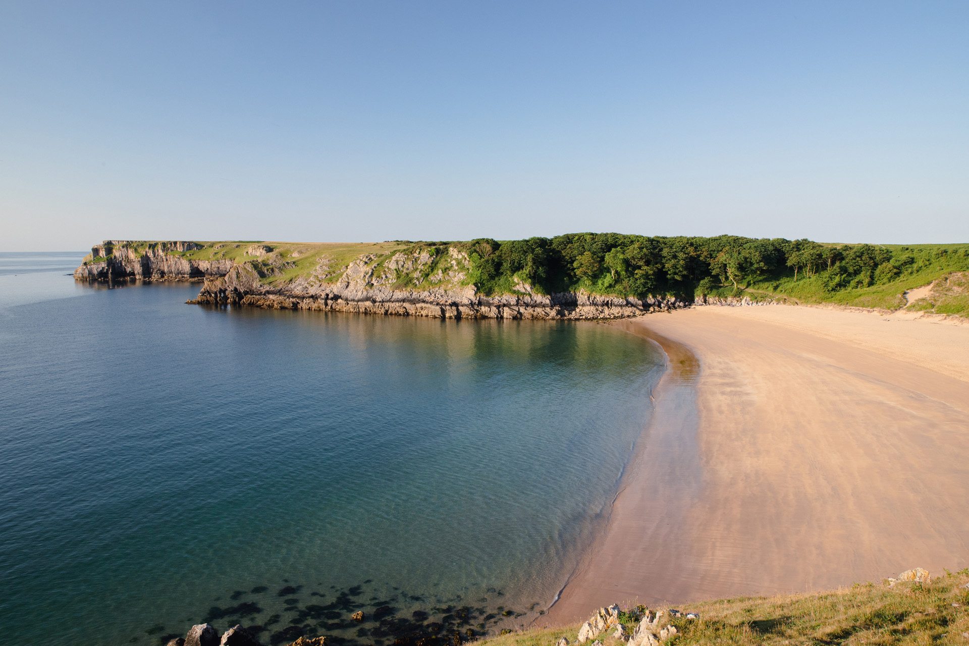 A beachy cove, completely empty with calm water
