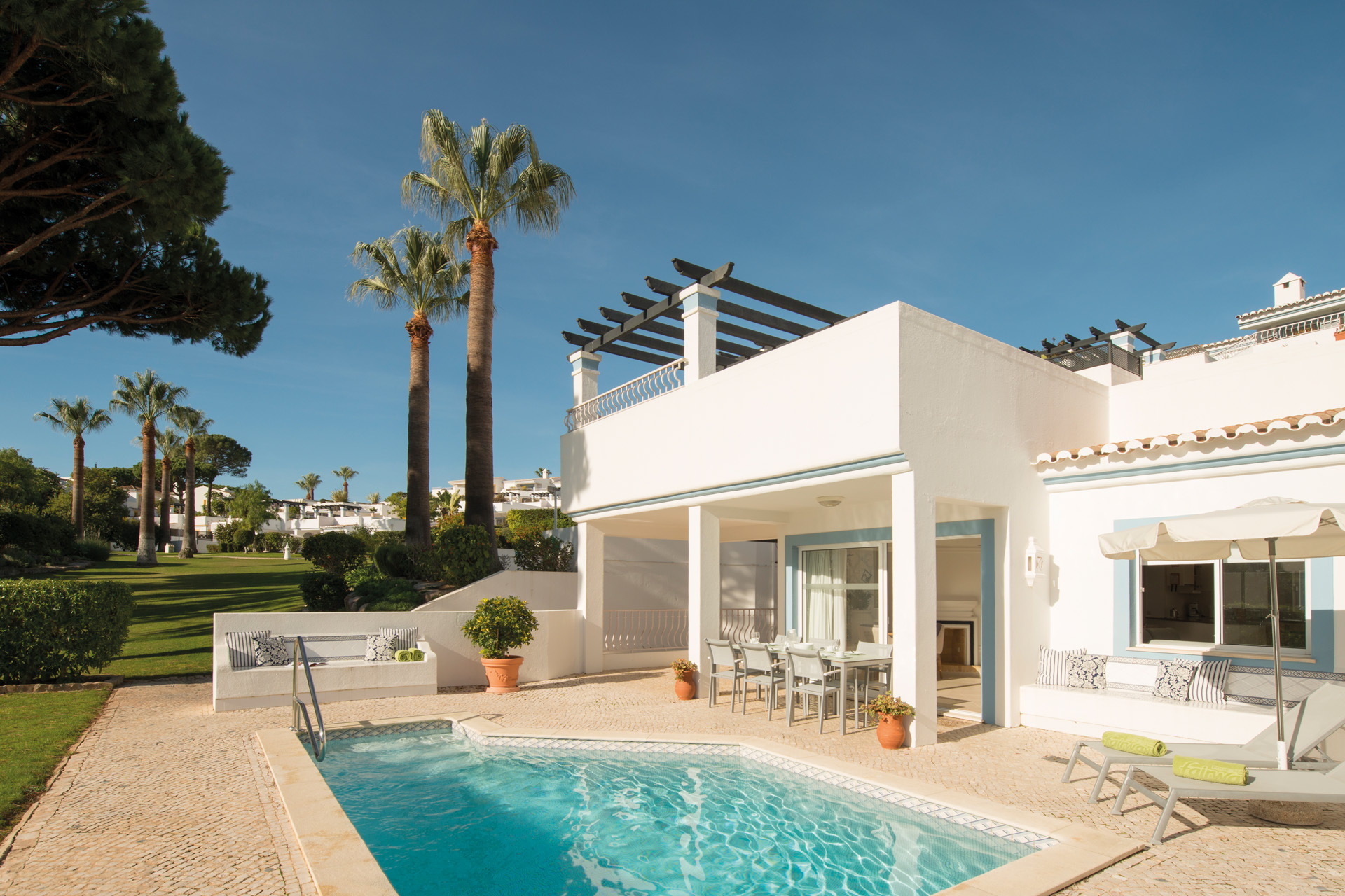 A white villa with a pool in front