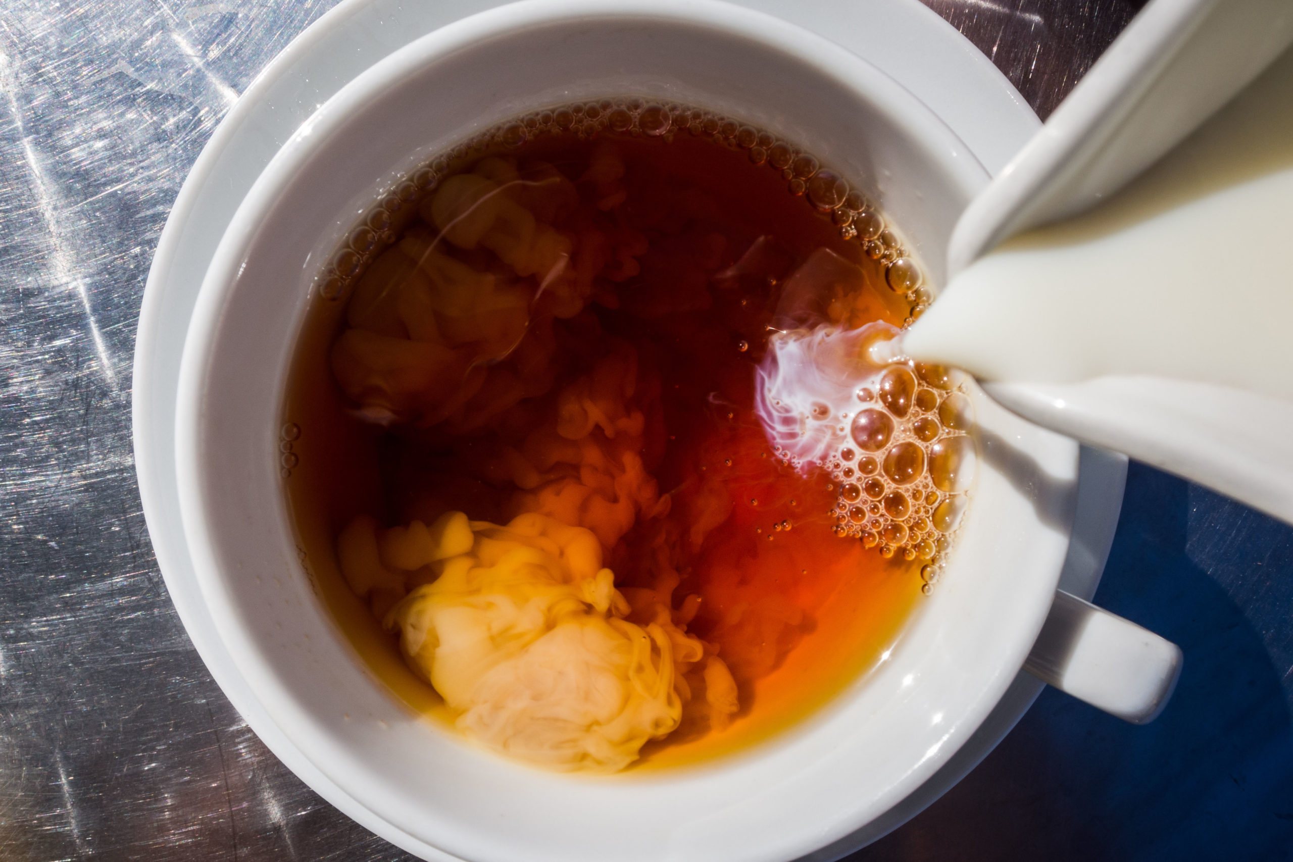 milk being poured into tea
