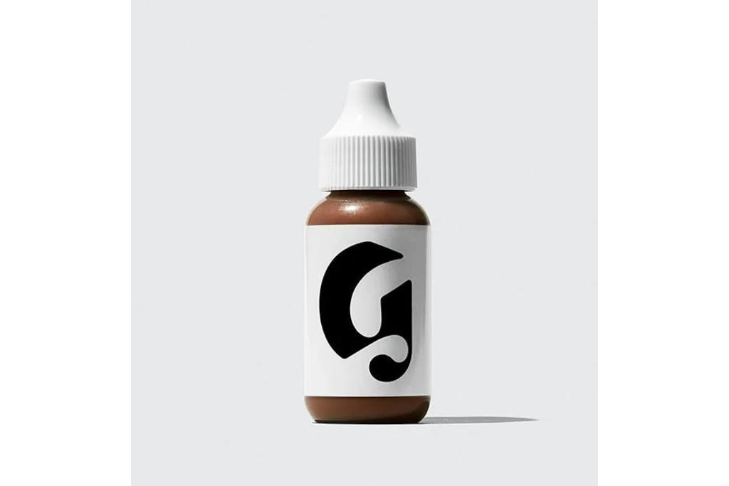 Brown bottle with white label and cap, with a large 'G' in black, gothic font