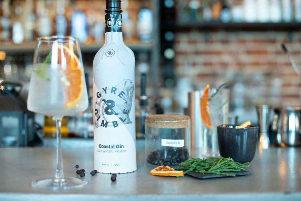 Bottle of gin with cocktail glasses and mixers