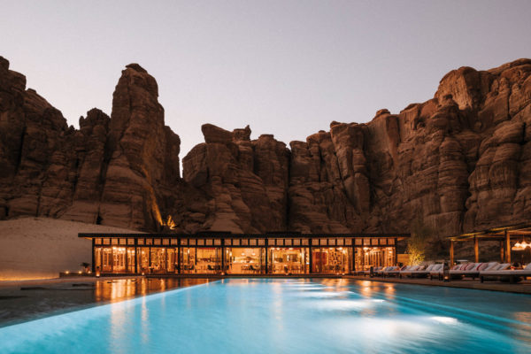 dusk with a swimming pool and single storey hotel with orange glow