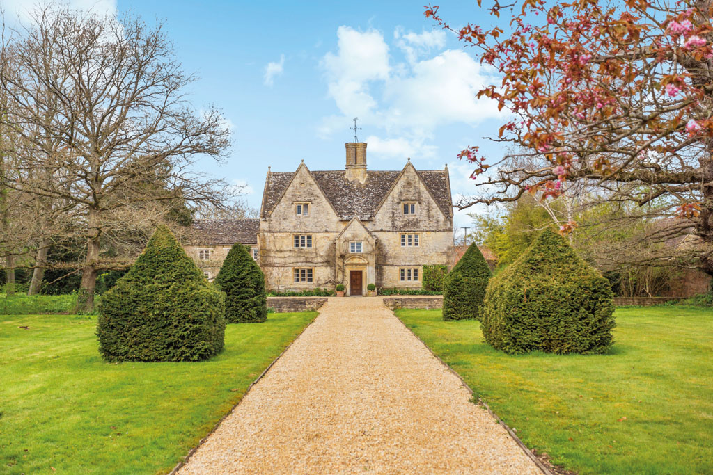 exterior shot of Jacobean manor house in Wiltshire with long drive and manicured gardens