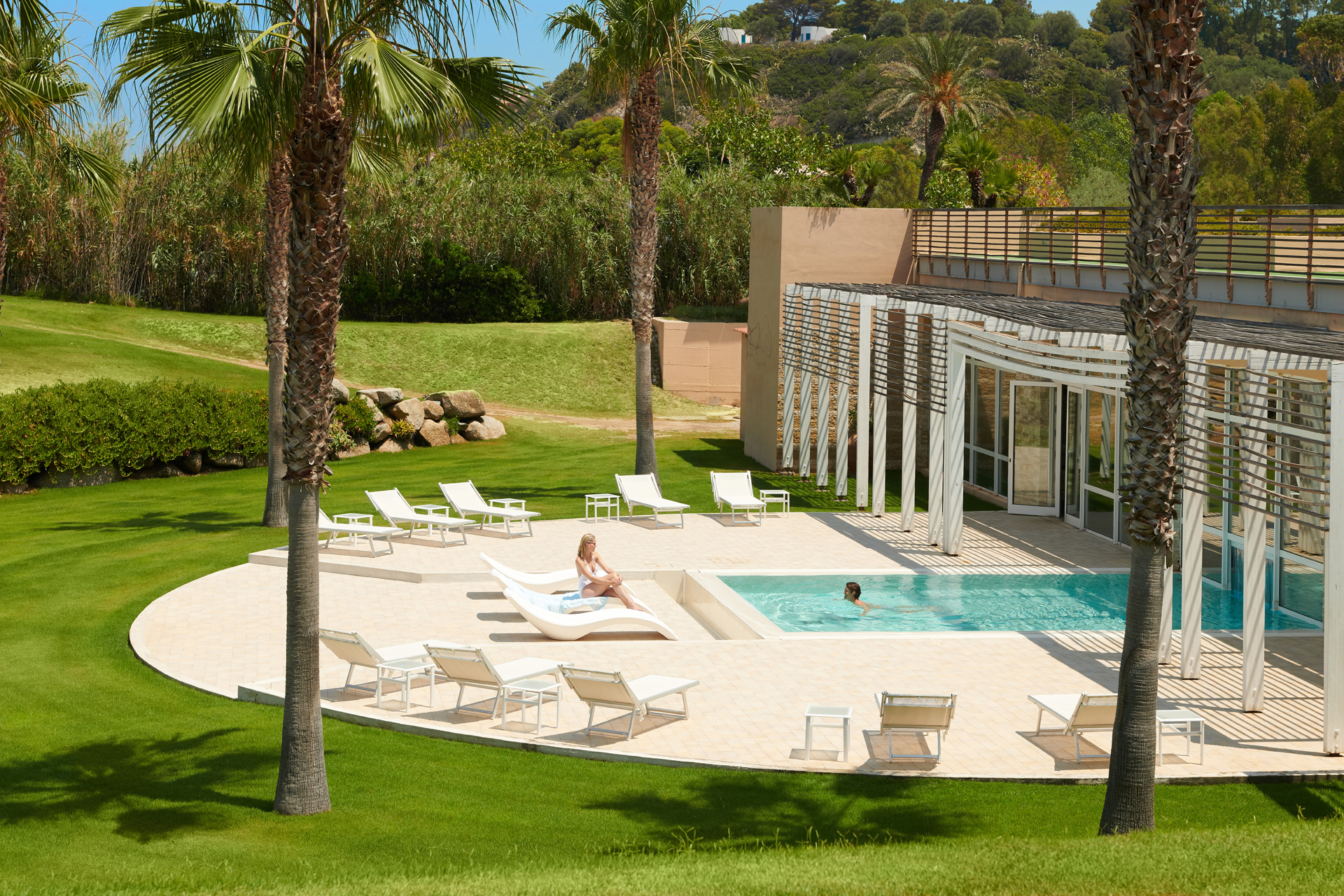 An outdoor pool surrounded by sunbeds