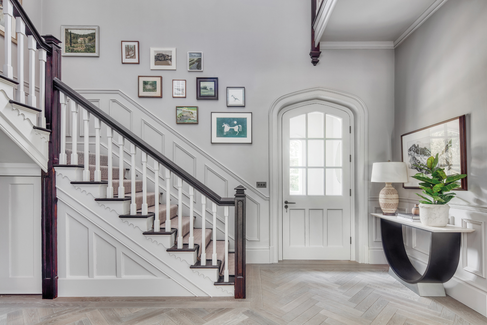 A staircase in a light entryway to a home, by Studio Hooton