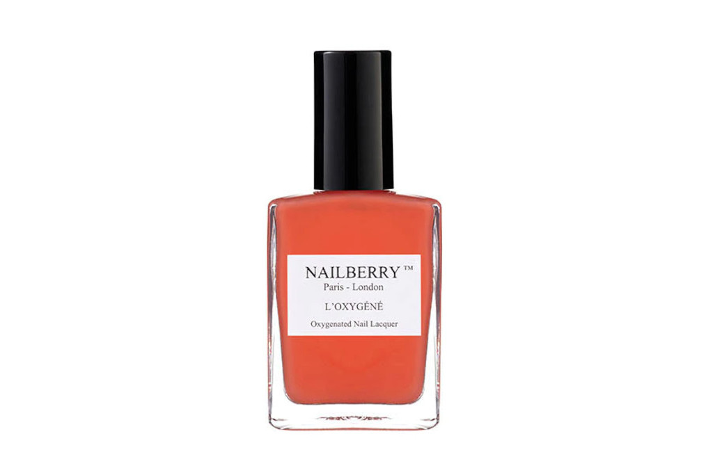 Bottle of orange nail varnish with black cap