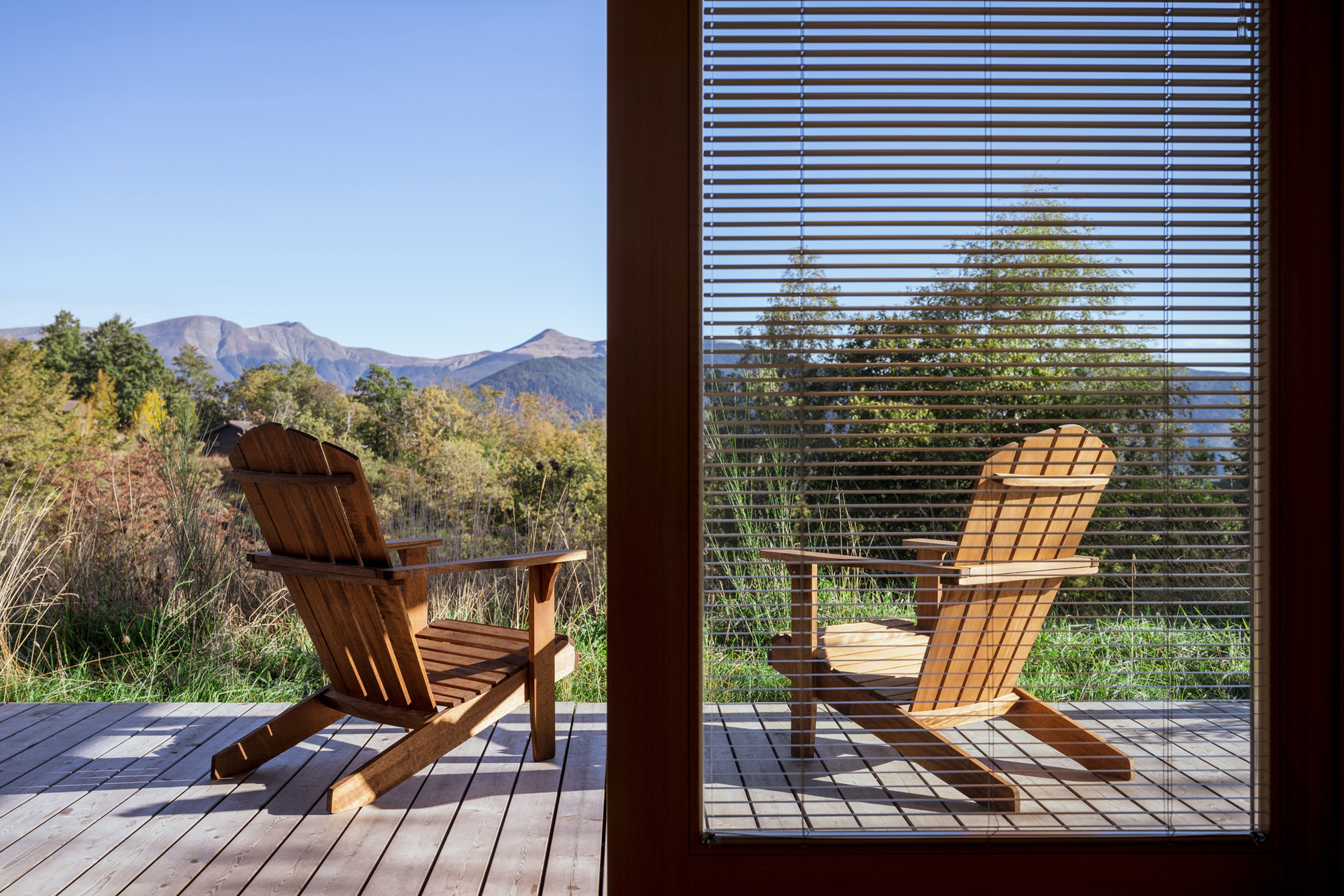 Two wooden chairs overlooking Tuscan forest