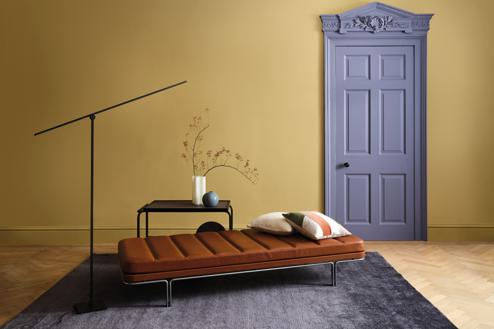 living room with cushioned stool and graphenstone yellow painted walls and blue painted door